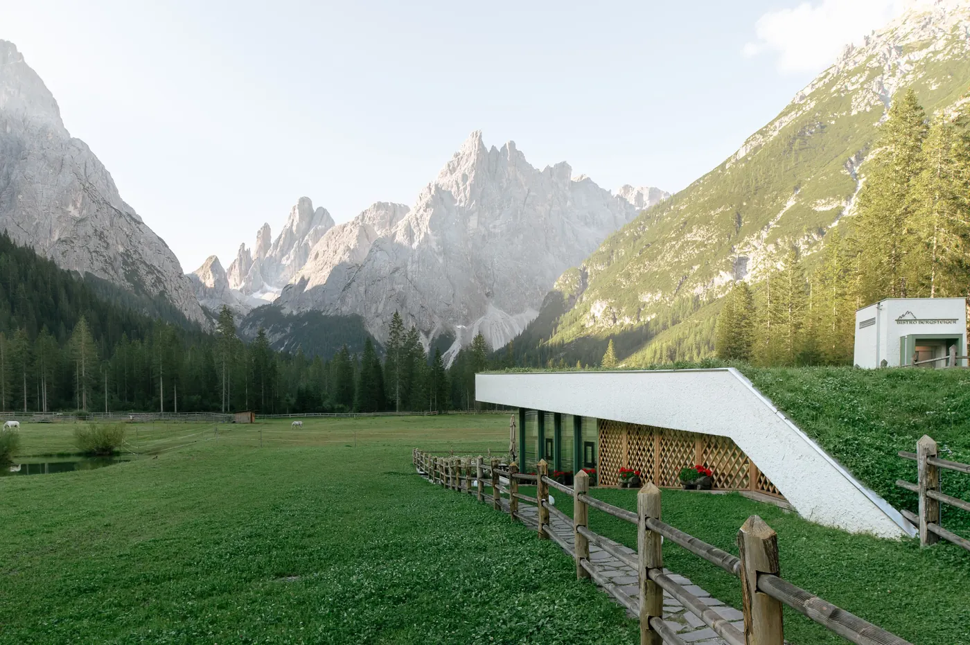 Das Bistro Bergsteiger mit begrüntem Dach vor den Gipfeln der Sextner Dolomiten