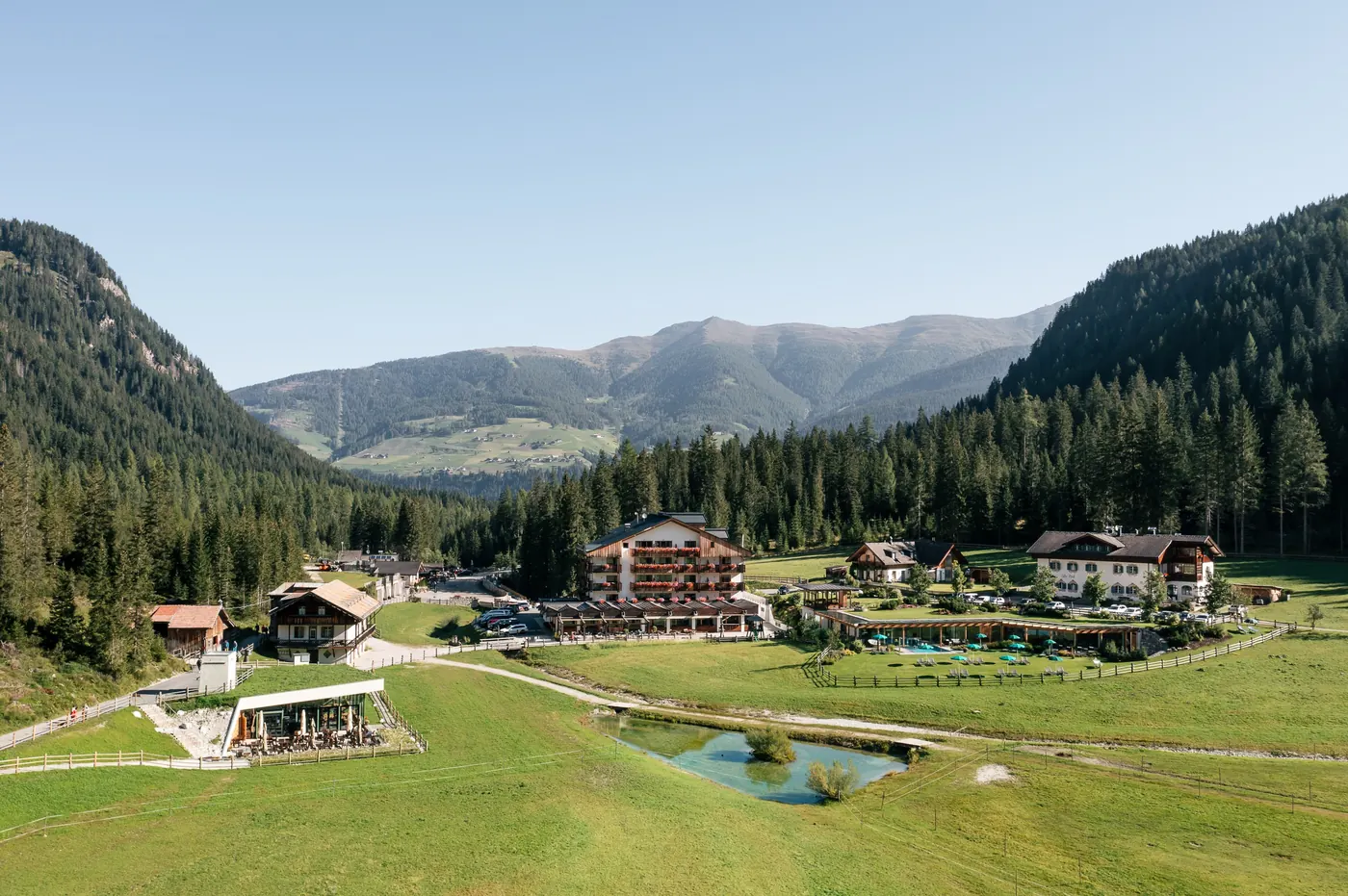 Luftaufnahme mit dem Bistro Bergsteiger im Vordergrund und dem Hotel Dolomitenhof dahinter